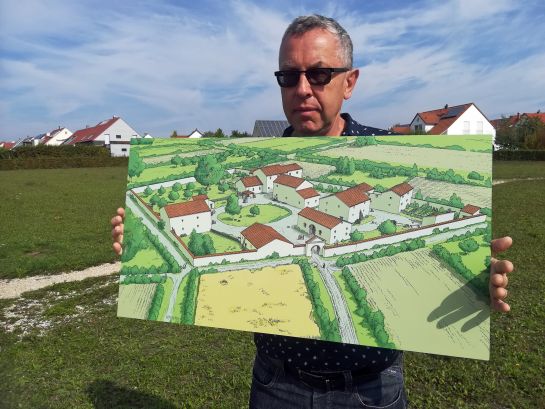 Fotografie: Dr. Lutz Dallmeier mit einer Karte der römischen Villa Rustica in Burgweinting