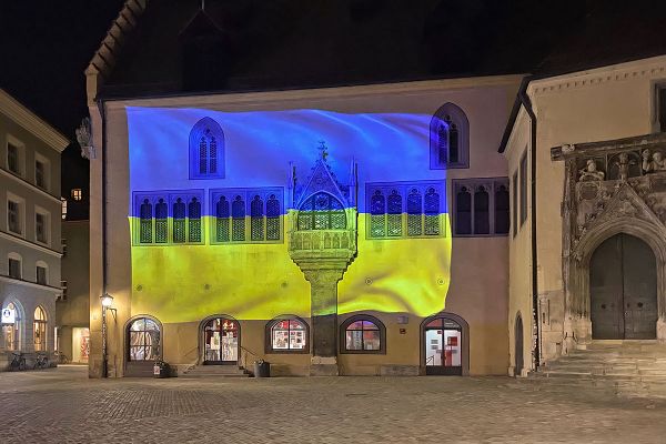 Fotografie: Projektion der ukrainischen Nationalflagge an der Außenfassade des Reichssaalgebäudes