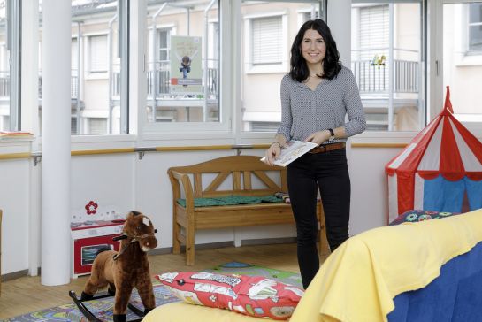 Fotografie – Verena Deubler steht inmitten von Spielzeug (C) Bilddokumentation Stadt Regensburg
