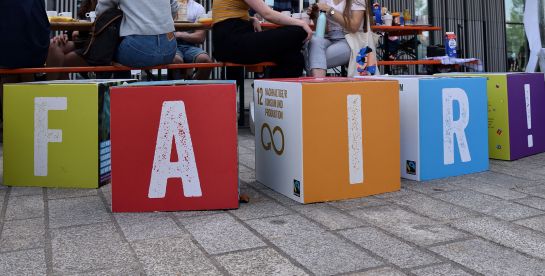 Fotografie: Vier bunte Würfel bilden das Wort „Fair“.