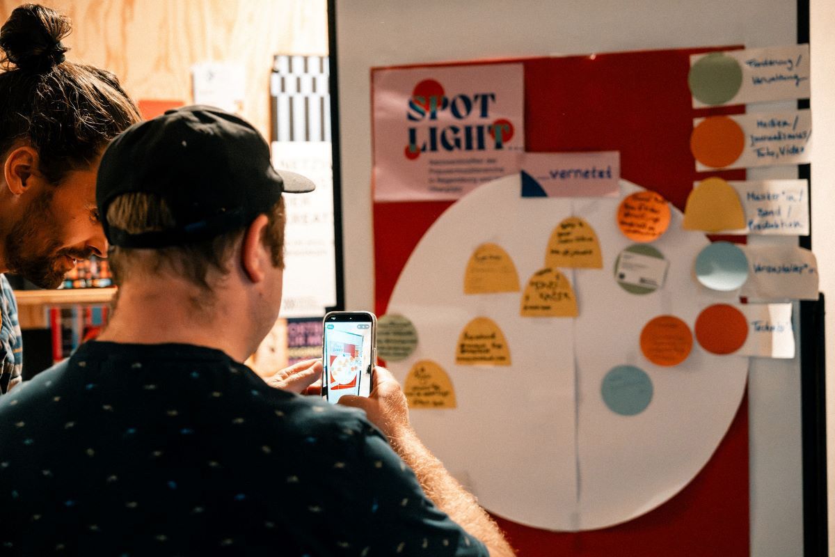 Fotografie: Teilnehmer vor Pinwand