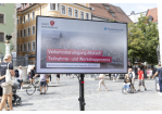 Fotografie: Das Foto zeigt einen auf dem Domplatz aufgebauten Bildschirm mit einer Präsentation mit dem Titel "Verkehrsberuhigung Altstadt - Teilnahme- und Workschopprozess". (C) Bilddokumentation Stadt Regensburg 