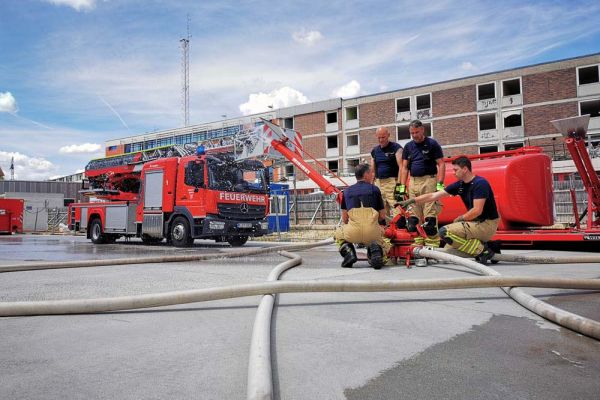 Feuerwehrbeamte bei der Ausbildung an einem Schaum - Wasserwerfer