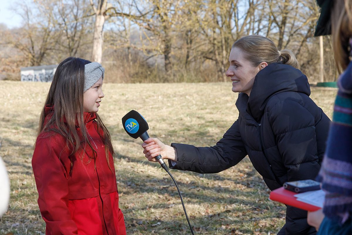 Fotografie - Eine Kinderbeirätin spricht in ein TVA-Mikrofon