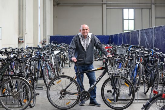 Fotografie: Manfred Stuber steht hinter einem Fahrrad.