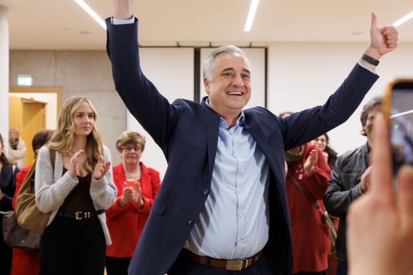 Fotografie: Dr. Thomas Burger reckt nach seinem Wahlsieg unter Applaus die Arme in die Höhe.