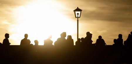 Themenbild Leben in Regensburg - Personen im Sonnenuntergang auf der Steinernen Brücke