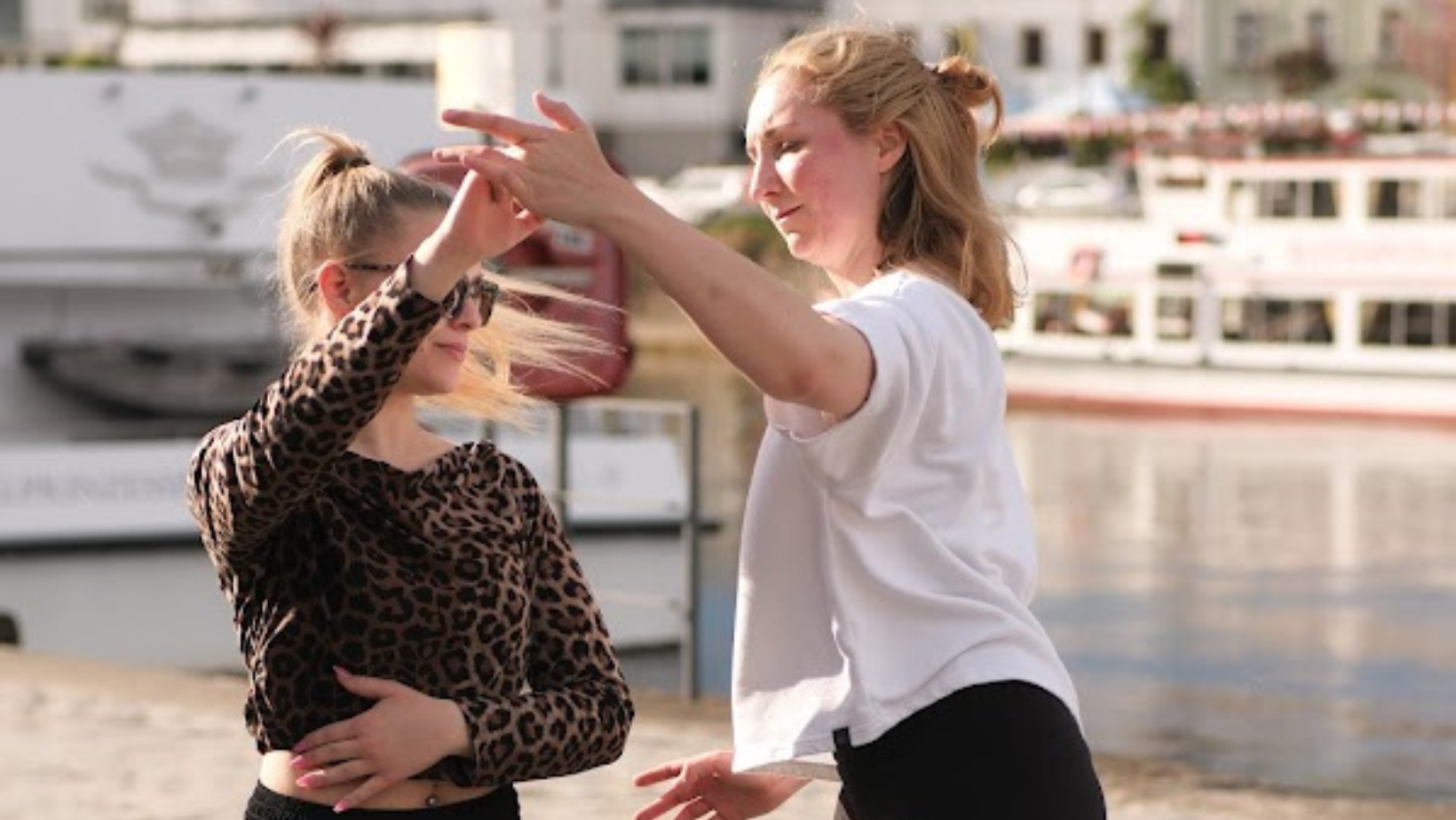 Auf der Abbildung ist Tine Lange mit einer Tanzpartnerin zu sehen. Sie sind draußen und üben einen Tanz zusammen aus, bei dem Tine die Person auf dem Bild in einer Tanzpose hält.