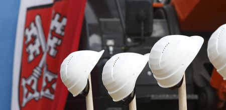 Themenbild Regensburg plant und baut - Fotografie - Bauhelme vor Flagge mit Stadtwappen