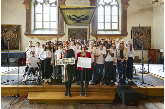 Fotografie: Oberbürgermeisterin Gertrud Maltz-Schwarzfischer (r.) und Isabelle Lavest, stellvertretende Bürgermeisterin für Kultur in Clermont-Ferrand mit den am Konzert beteiligten Musikerinnen und Musikern