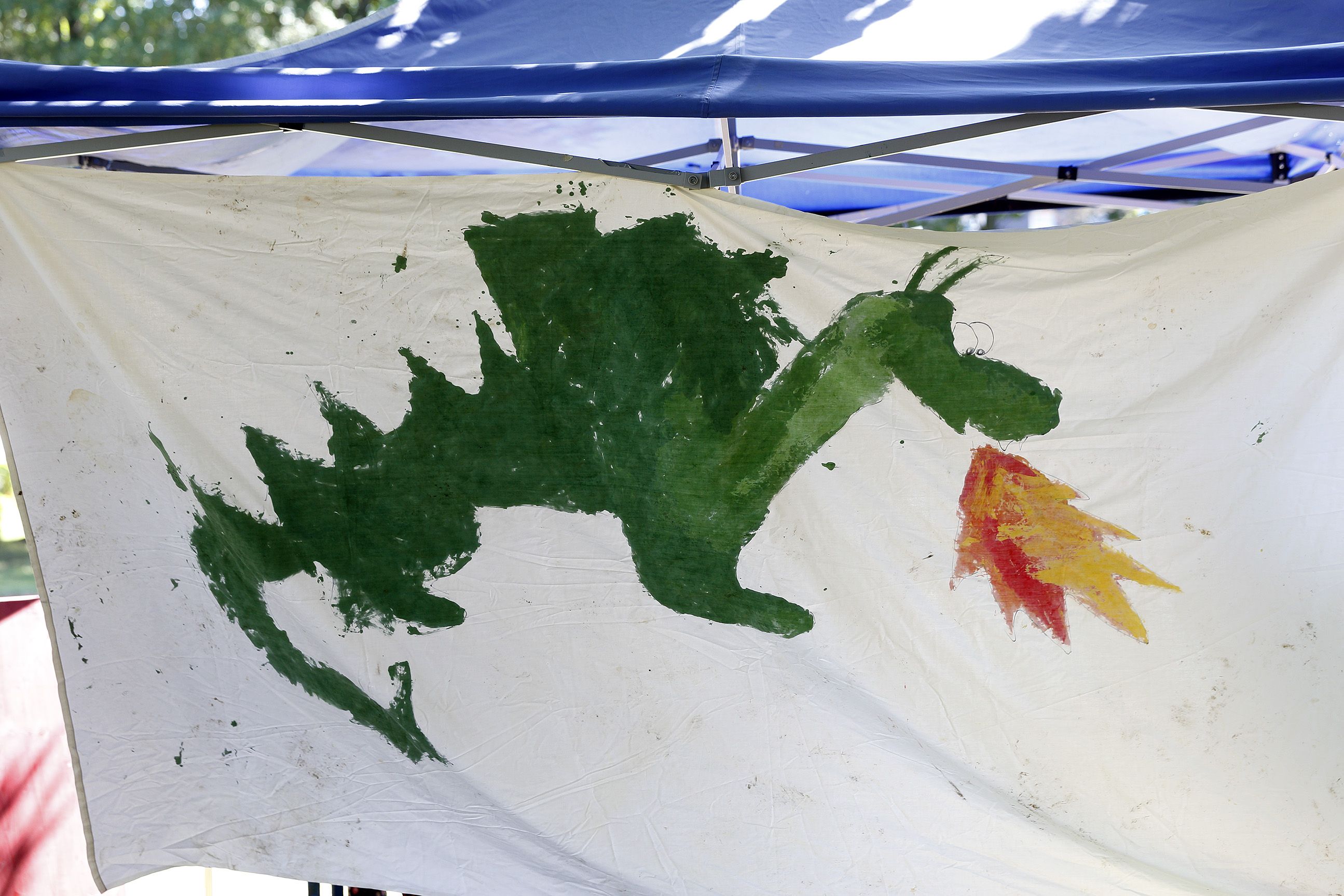Fotografie - gemalter Drache, der Feuer spuckt auf auf weißem Banner