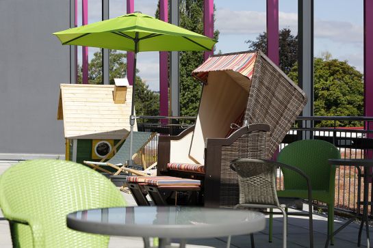 Foto Dachterrasse mit Strandkorb, Sonnenschirm und Gartenstühlen