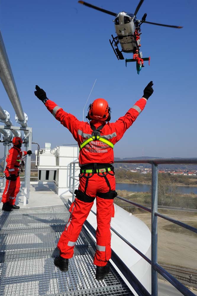 Fotografie: Höhenretter der Berufsfeuerwehr Regensburg beim Einweisen eines Hubschraubers.