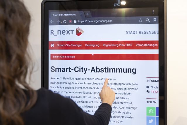 Frau an interaktiven Smart-Board bei Smart-City-Abstimmung
