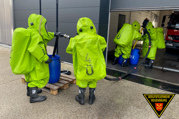 Fotografie: Einsatzkräfte der Feuerwehr mit Chemikalienschutzanzügen bei einer Übung.