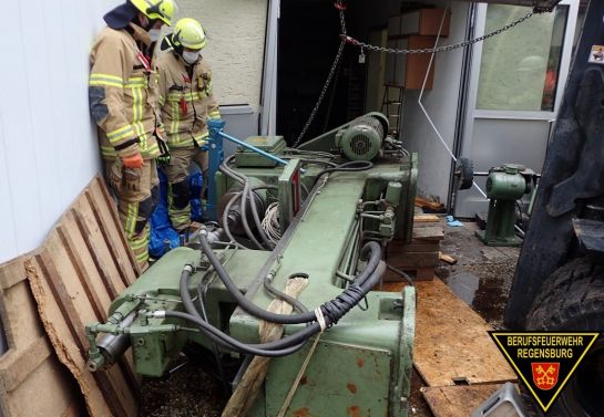 Zwei Feuerwehrmänner begutachten die umgestürzte Maschine