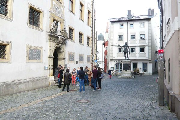Fotografie - eine Gruppe Menschen steht in der Regensburger Altstadt bei einem Rundgang