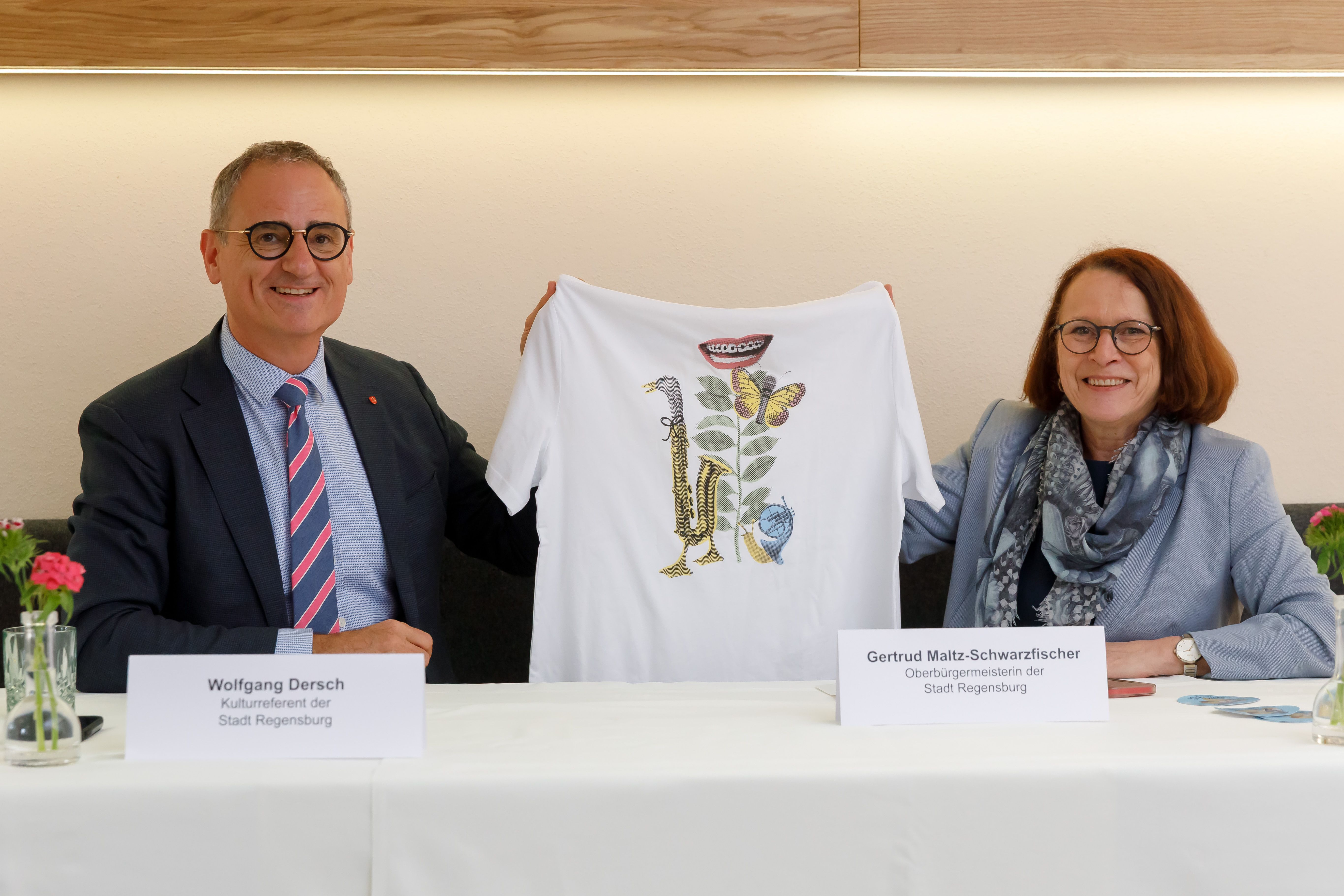 Fotografie – Kulturreferent Wolfgang Dersch und Oberbürgermeisterin Gertrud Maltz-Schwarzfischer zeigen das Bürgerfest-T-Shirt 2025