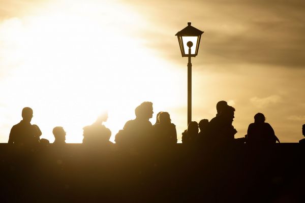 Themenbild Leben in Regensburg - Personen im Sonnenuntergang auf der Steinernen Brücke