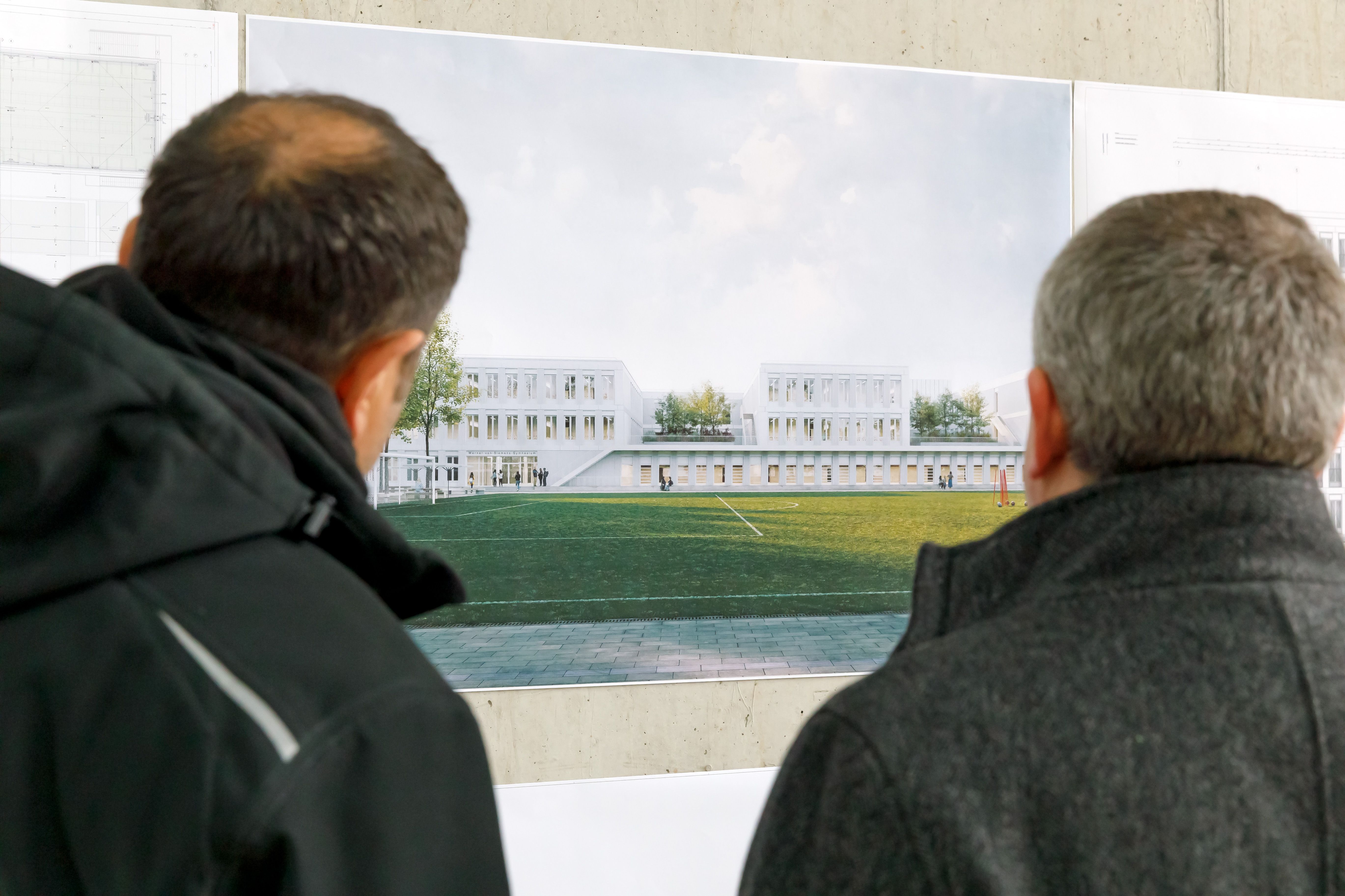 Fotografie: Zwei Männer betrachten die Pläne für das Werner-von-Siemens Gymnasium.