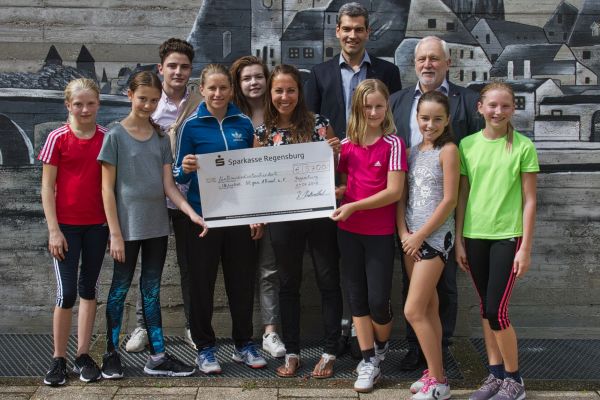 Frau Stefanie Eichenseer überreicht an Frau Maria Schneeberger von INGEAR den Erlös des diesjährigen Sponsorlaufs. Im Bildhintergrund (v.r.): Herr Dr. Hage, OStD Ralf Krottenthaler, Anna Wolbergs, Taner Tuna (Schülersprecher)