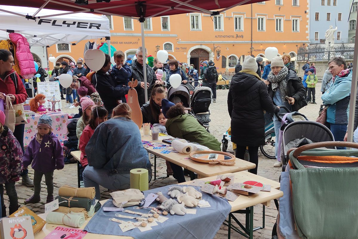 Menschen mit Kindern an einem Flohmarktstand