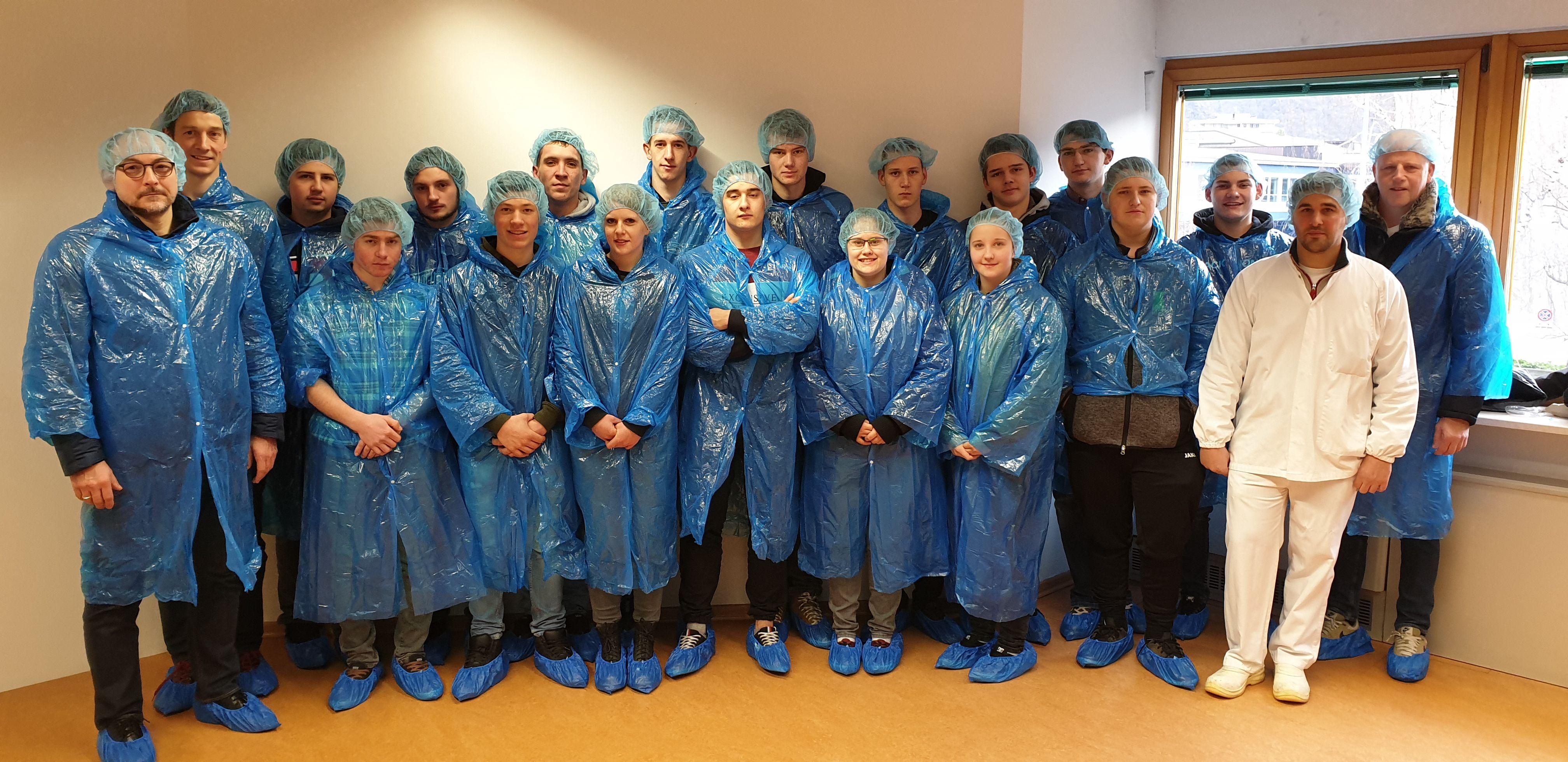 Fleischerinnen und Fleischer in blauen Schutzmänteln im Gruppenbild
