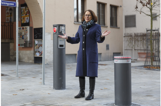 Fotografie: Oberbürgermeisterin Gertrud Maltz-Schwarzfischer steht neben dem ersten versenkbaren Poller, der im Herbst 2022 auf dem Hunnenplatz installiert wurde. 