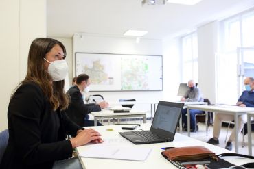 Fotografie: Verena Schmid sitzt vor einem Laptop.