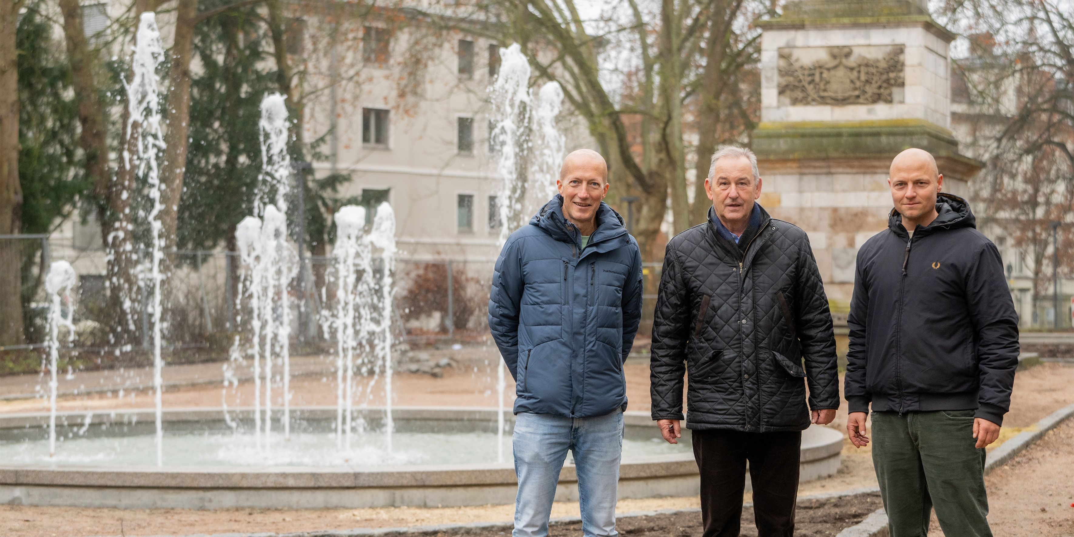 Fotografie – (v. l. n. r.) Sascha Fieml, Bürgermeister Ludwig Artinger und Michael Daschner, Leiter des Gartenamtes, beim Probelauf des Brunnens