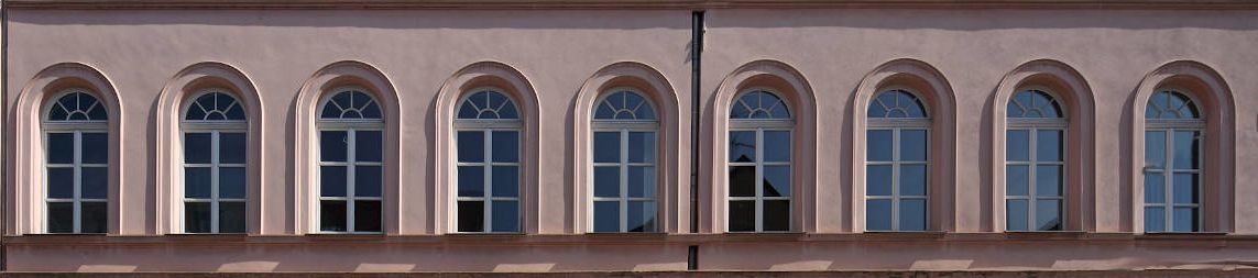 Reihe von Fenstern an rosa Hauswand
