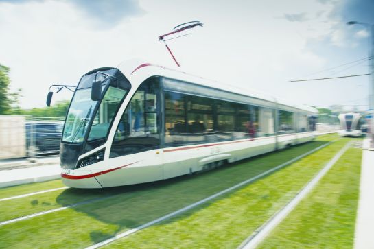 Grafik: Eine Stadtbahn fährt auf einer begrünten Spur. (C) istockphoto.com/shellexx