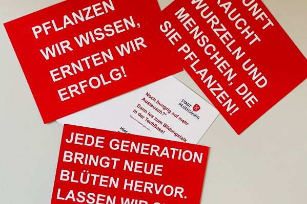 Fotografie: Anregungen zum Bildungstalk liegen als Karten auf einem Tisch, dazu eine Einladung zur Veranstaltung.