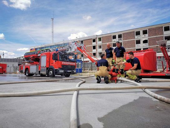 Feuerwehrbeamte bei der Ausbildung an einem Schaum - Wasserwerfer