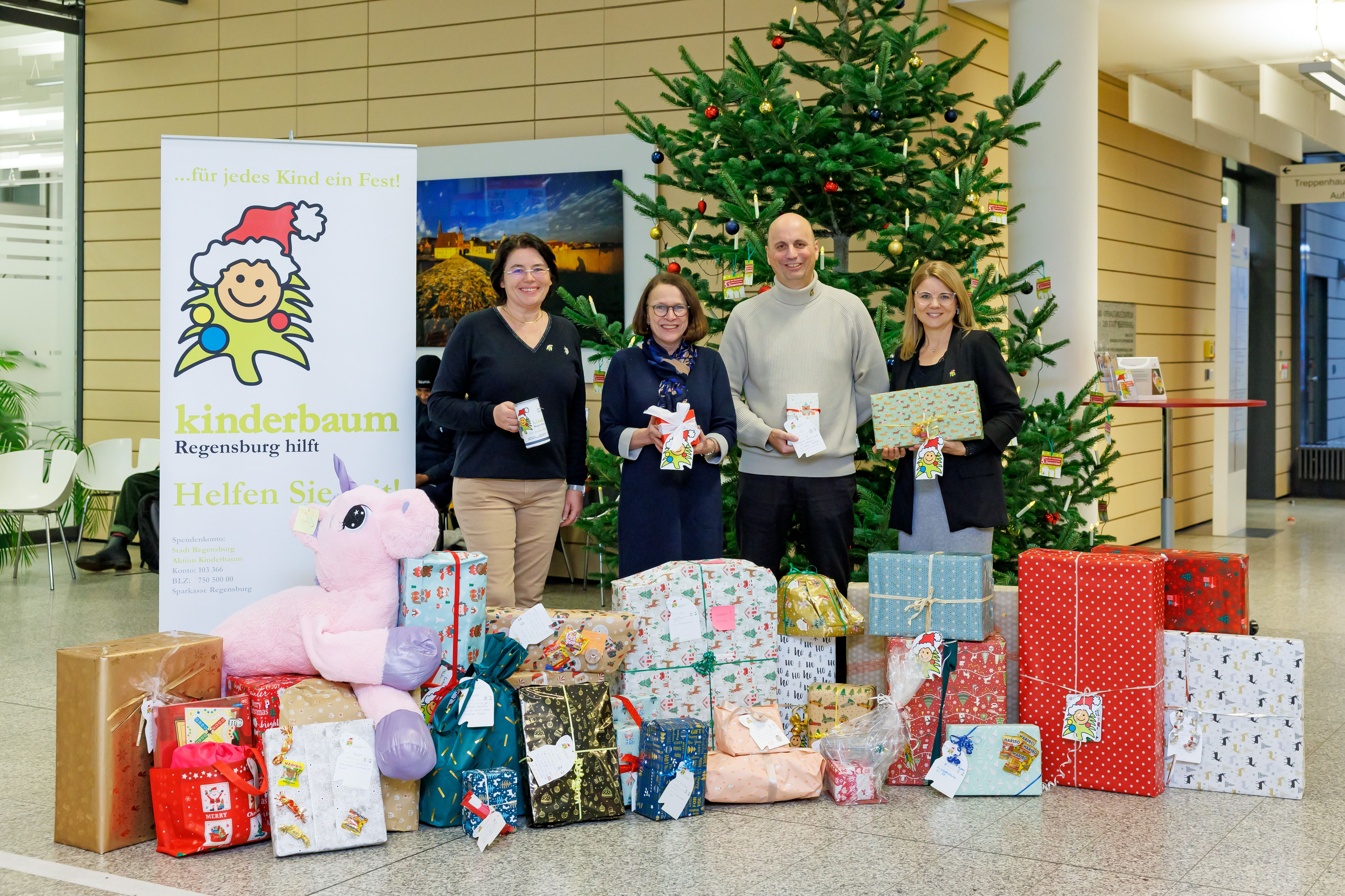 Foto, Fa. Schneider Electric übergeben Geschenke an die Oberürgermeisterin vor dem Kinderbaum