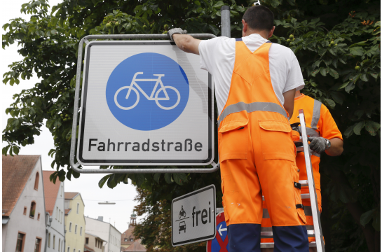 Mitarbeiter der Stadt Regensburg bringen das Verkehrsschild "Fahrradstraßen" an. 