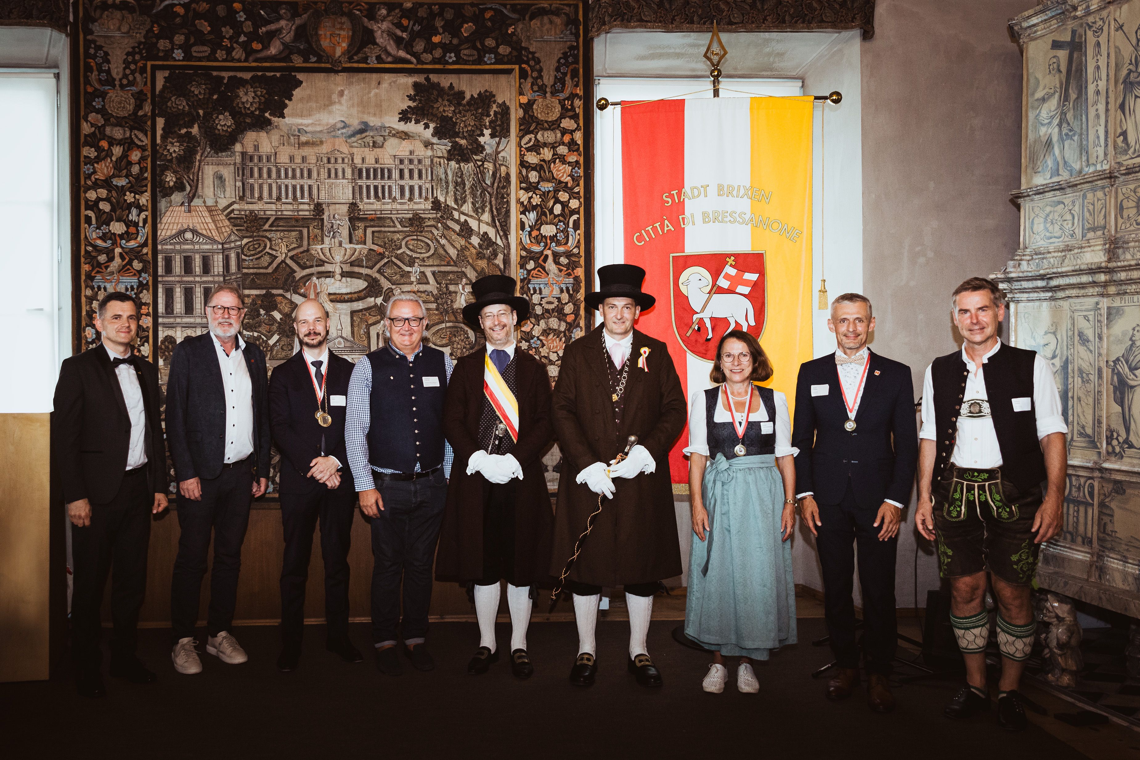 Fotografie: Oberbürgermeisterin Gertrud Maltz-Schwarzfischer mit dem Brixener Bürgermeister Andreas Jungmann (4. v. r.) und Vizebürgermeister Ferdinando Stablum (4. v. l.) sowie dem Präsidenten des Altstadtfestkomitees Joachim Kerer (Mitte) und Vertretern der befreundeten Städte von Brixen beim feierlichen Empfang im Kaisersaal der Hofburg Brixen 2024