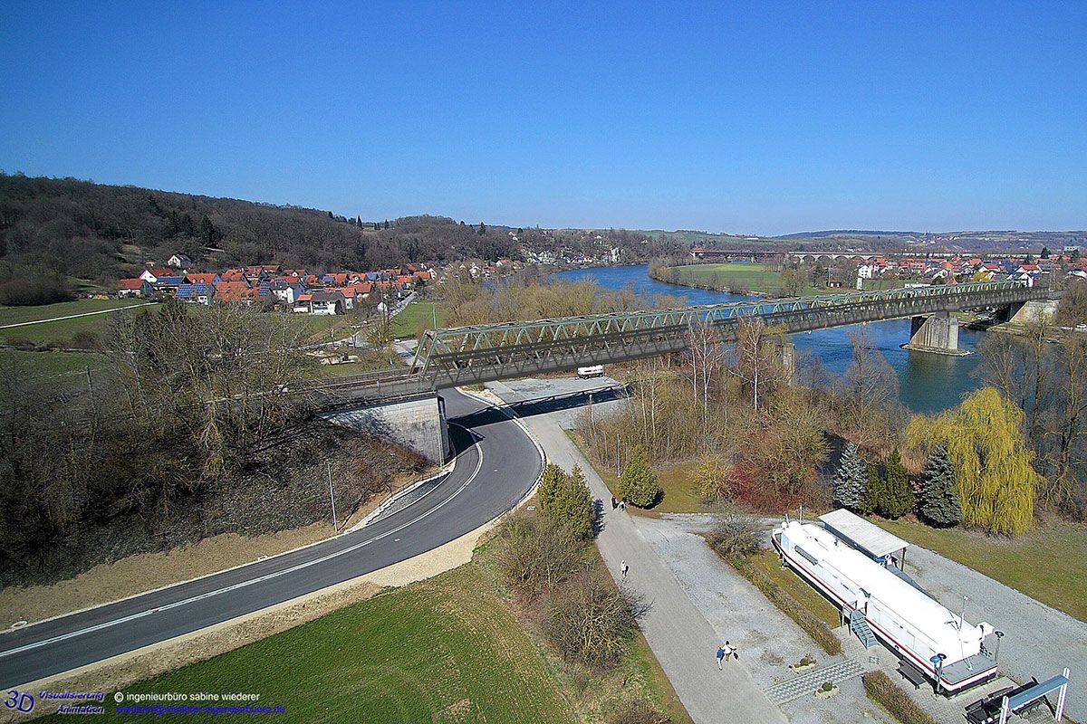 Neubau Geh- und Radwegbrücke Sinzing-Regensburg – Vogelperspektive der neuen Brücke (grau) von Seite Sinzing, im Hintergrund ist die vorhandene Eisenbahnbrücke (grün) zu erkennen.