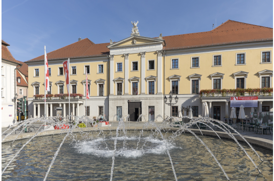 Fotografie: Das Foto zeigt das Theater am Bismarckplatz im Hintergrund und den Brunnen im Vordergrund. 