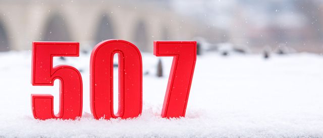 Fotografie: Rote 507-Ziffern stehen im Schnee vor der Steinernen Brücke.