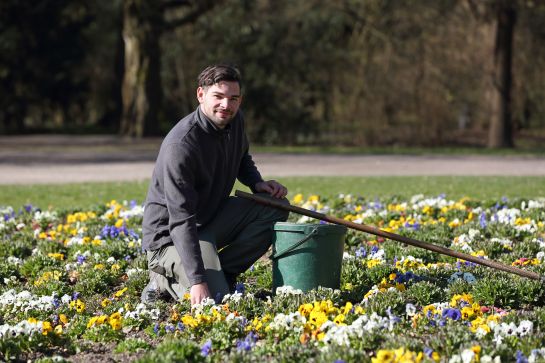 Fotografie: Matthias Peter kniet in einem Blumenbeet