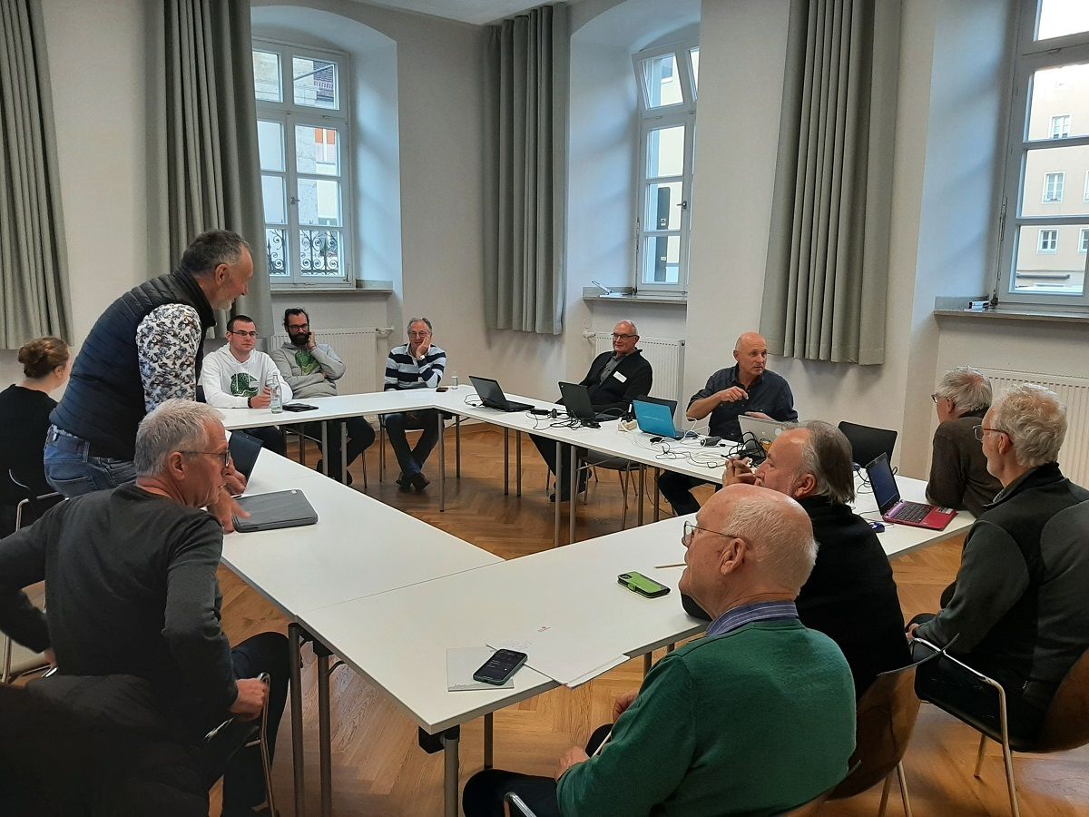 Teilnehmende sitzen an einem Tisch und diskutieren Themen rund um das Ehrenamt. 