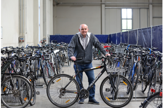 Fotografie: Manfred Stuber steht hinter einem Fahrrad.