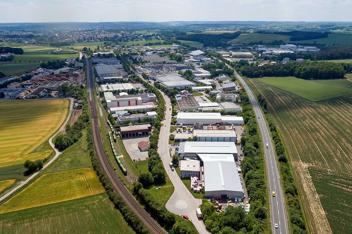 Fotografie - Luftbildaufnahme vom Gewerbegebiet Haslbach, rechts im Bild die Bundesstraße B 16 und links das Industriestammgleis Wutzlhofen, im Hintergrund Stadtgebiet Regensburg