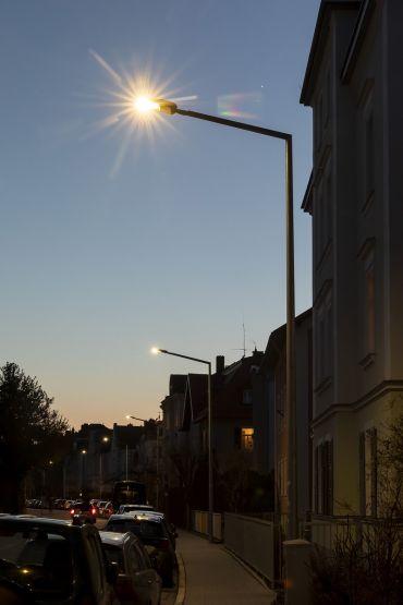 Fotografie: Mehrere eingeschaltete Straßenlaternen in der Dämmerung