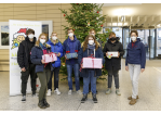 Fotografie - Kinder stehen vor einem Weihnachtsbaum und halten Geschenke in den Händen (C) Bilddokumentation Stadt Regensburg