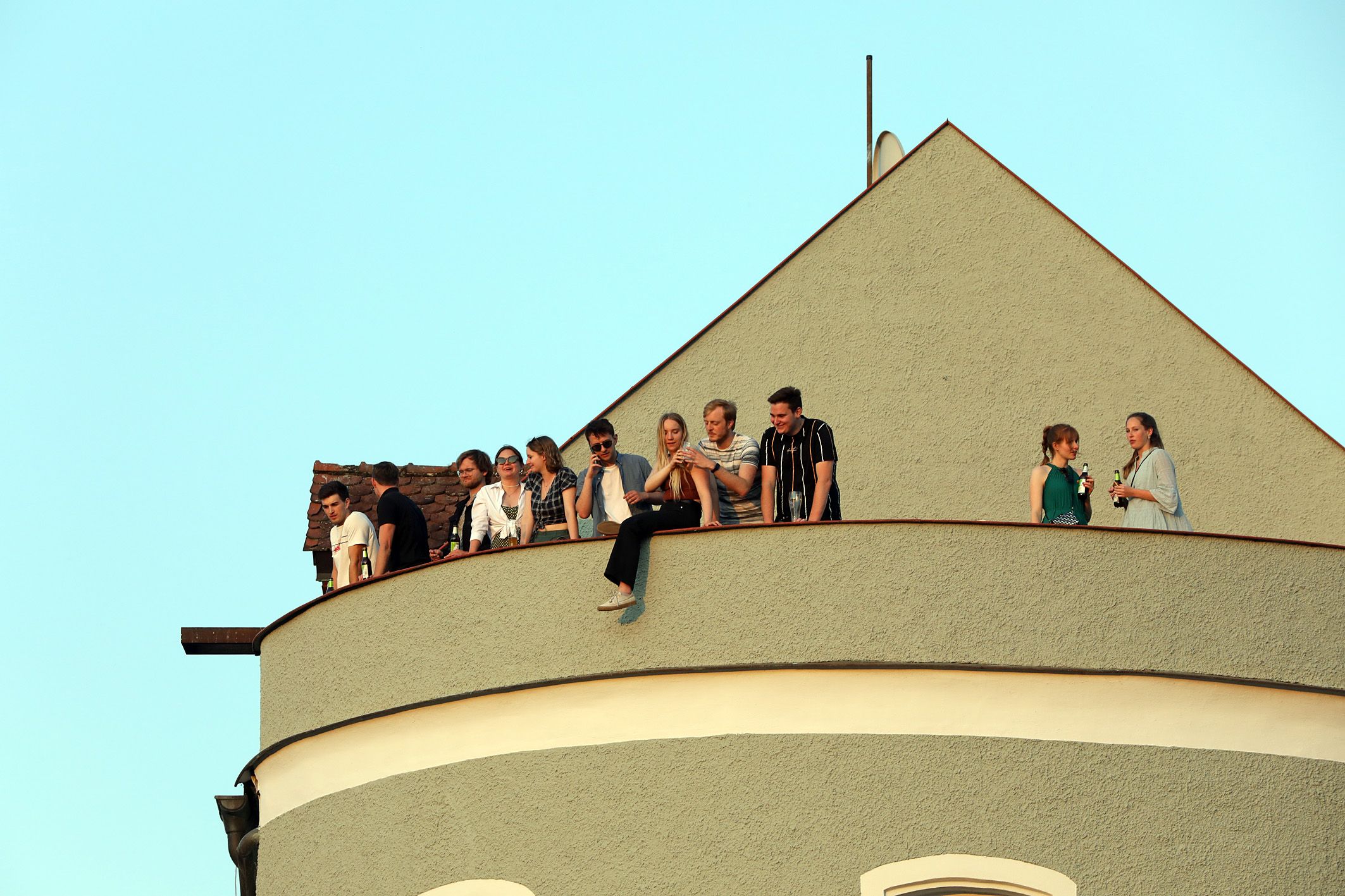 Fotografie: Menschen genießen den Ausblick von einer Dachterrasse. 