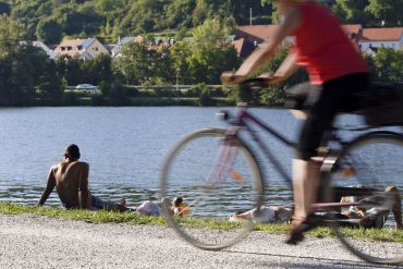 Fotografie: Das Foto zeigt einen Radfahrer, der an der Donau entlang fährt. 