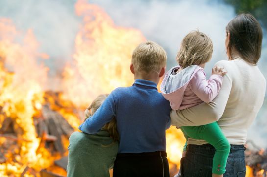 Fotografie: Familie steht vor einem Feuer