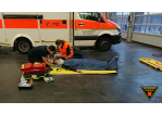 Fotografie: Teilnehmer einer Rettungssanitäter-Abschlussprüfung bei der Versorgung eines am Boden liegenden Patienten. (C) BF Regensburg